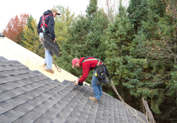 Roofers installing new roofing shingles on a home in Canton, CT.
